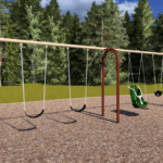May show: A playground swing set with four standard swings, one green adaptive swing, and one black bucket swing, set on a mulch surface with trees in the background.